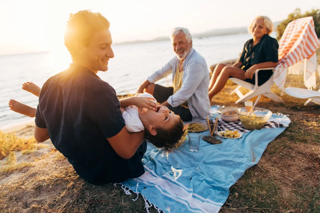a family enjoying a picnic as the sun sets