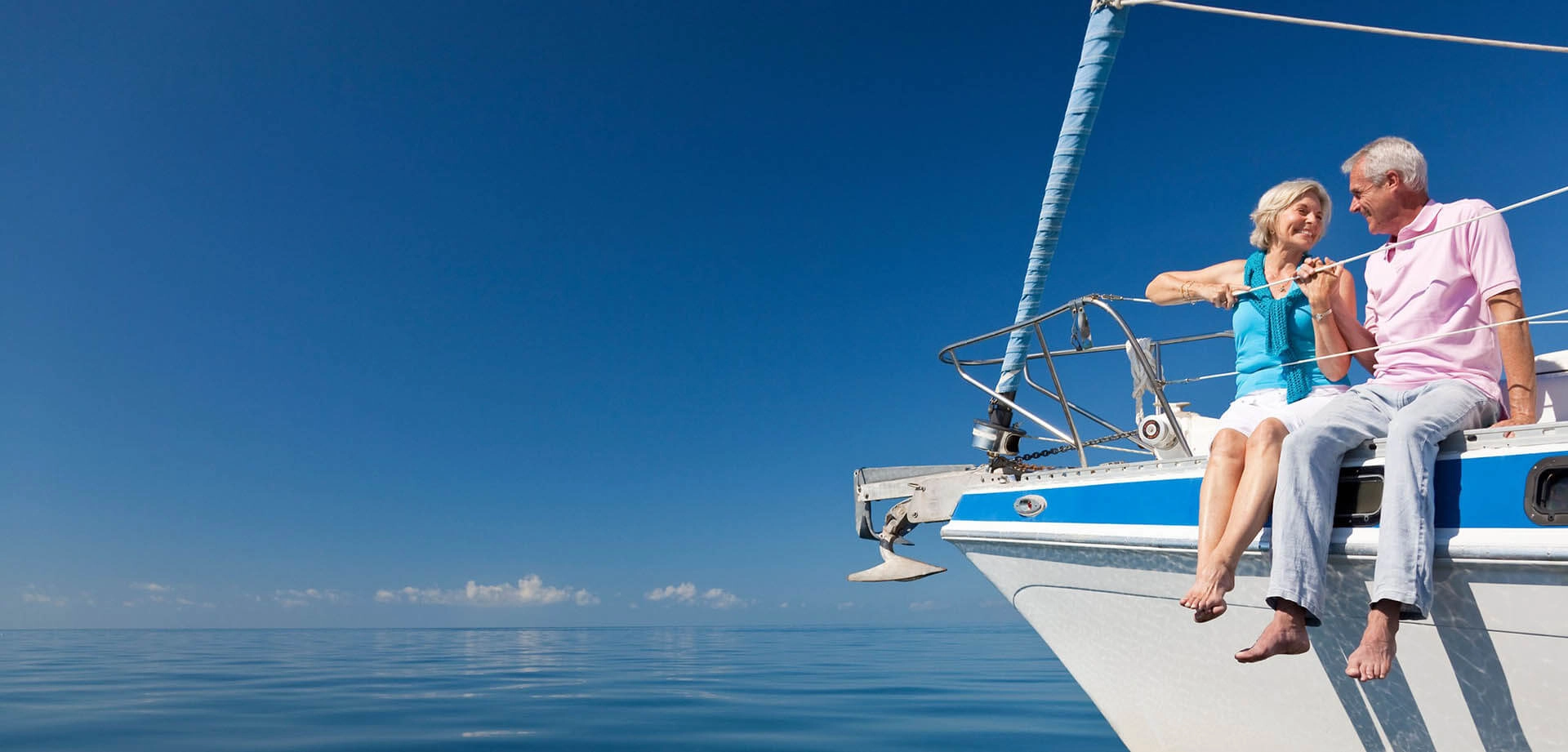 Older couple dangling their feet over side of boat