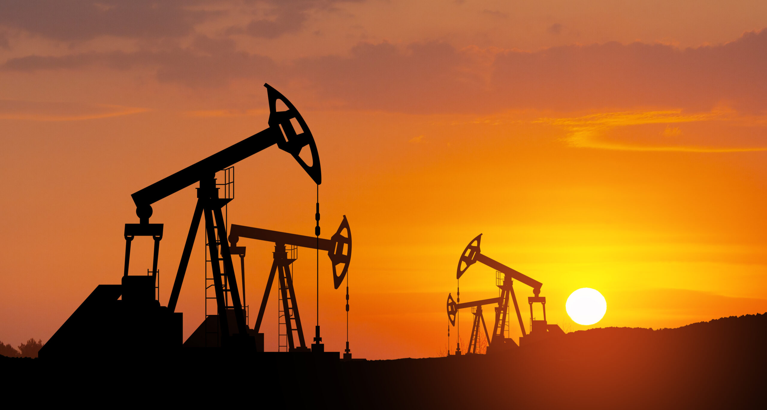 Oil drilling derricks at desert oilfield. The change in oil prices caused by the war. Oil price cap concept.